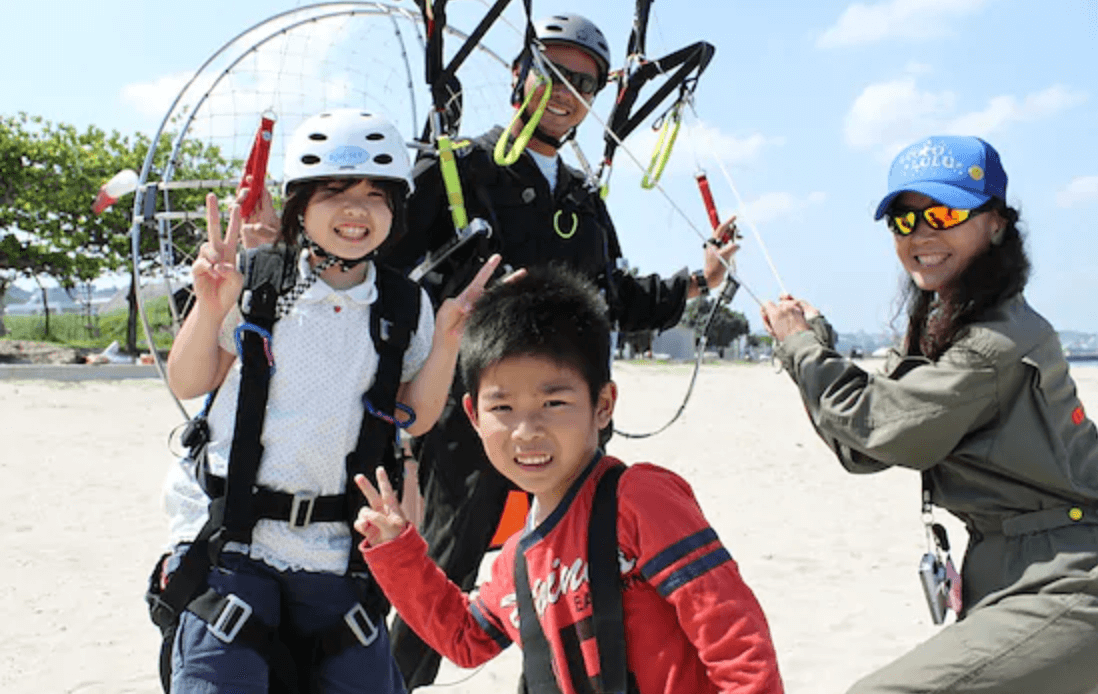 在沖繩玩飛行傘注意要綁緊手繩，以防在半空中跌下手機或相機。